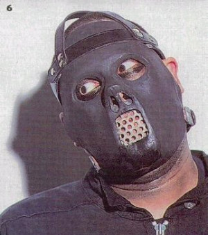 Mask - Paul wears a latex pig's face mask. MEANING: 