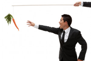 Businessman reaching for carrot on a stick