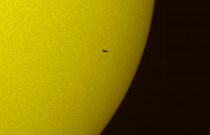 the ground using a telescope with a solar filter shows the NASA space ...