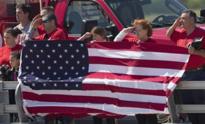 Firefighters and their family members salute a convoy of emergency ...