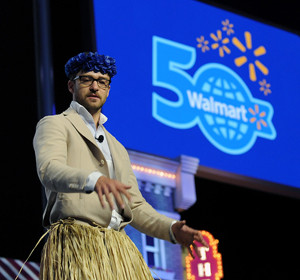 Justin wears skirt & lei hosting Wal-Mart's 50th b'day party