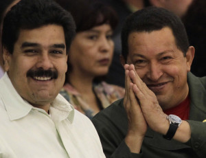 Venezuela's President Hugo Chavez (R) gestures next to Nicolas Maduro ...