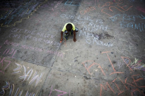 Young boy chalks a sidewalk following the police killing of Michael ...