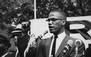 Malcolm X gives a speech at an outdoor rally in 1963.