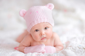 Cute portrait newborn girl baby in pink knitted bear hat