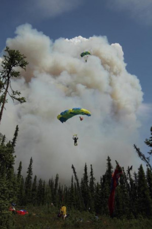 Hastings fire. Two smokejumpers approaching landing zone in clearing ...