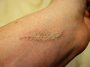 See more Feather white ink tattoo on wrist