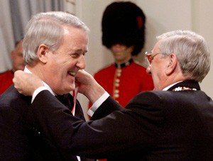 Former prime minister Brian Mulroney laughs while Roméo LeBlanc puts ...
