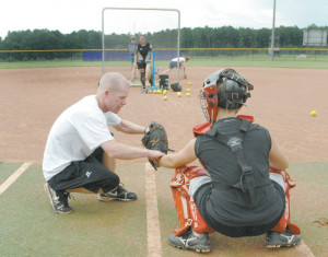 East Coweta softball coach Matt East works with catcher Hailey Baswell ...