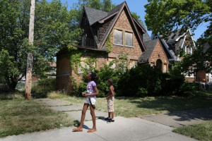 Jasmine Clark, 11, and Lamario Reese, 8, walk by an empty home near J ...