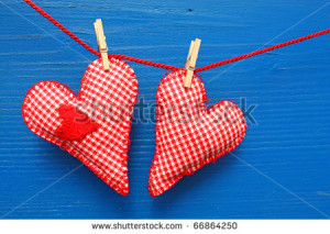 ... sewn hearts hanging on a line against a blue wall - stock photo
