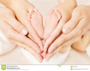 Stock Photography: Newborn baby feet parents holding in hands.