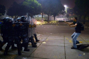 Brazilian protester stands before gunfire during protests against ...