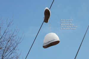 sneaker hanging from power lines, blue sky with a quote: