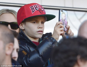 Snap happy! Romeo Beckham swapped his Bieber phone cover for a picture ...