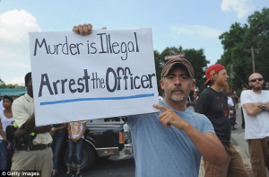 Ferguson resident holds a sign during a protest of the shooting ...