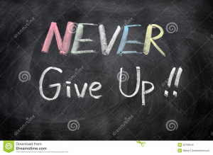 Never give up written in chalk on a blackboard.