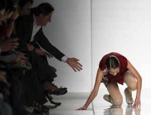 model falls as she displays a creation as part of Mila Schon Spring ...