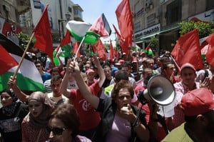 Palestinians wave national and PFLP flags during a protest in the West ...