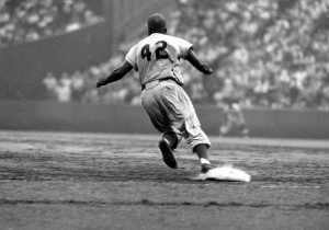 Jackie Robinson rounds first base in a 1956 game against the New York ...