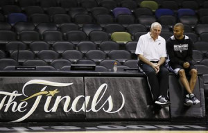 Antonio Spurs coach Gregg Popovich (L) sits with player Tony Parker ...