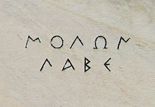 The words ΜΟΛΩΝ ΛΑΒΕ as they are inscribed on the marble of ...