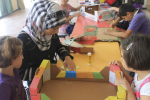 Translator Ruba helping make a cardboard creation