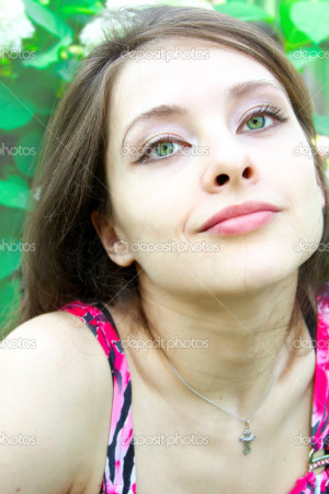 Portrait of beautiful girl with green eyes on flowers background ...