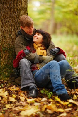 Romantic couple sitting under a tree together Stock photo