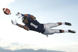 African American football player catching ball - Blend Images - Pete ...
