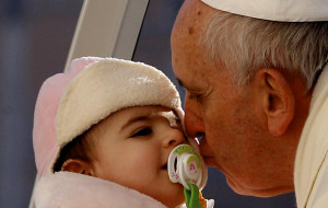 Pope Francis kisses a baby as he arrives to lead his final 2013 ...
