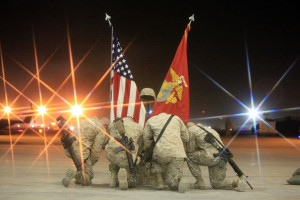 Marines kneel beside the battlefield cross to pay their final respects ...