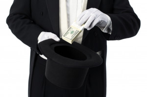 Magician pulling money out of hat on white background