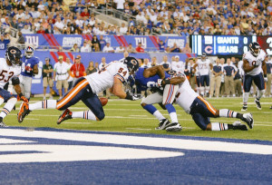 Brian Iwuh and Brian Urlacher strip the ball from Giants' Mario ...