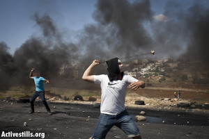 Palestinian youth throw stones near Ofer Military Prison [illustrative ...