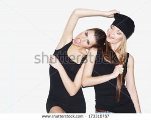 Two young girl friends standing together and having fun. Brunette ...