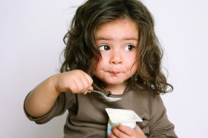 Little girl eating yogurt
