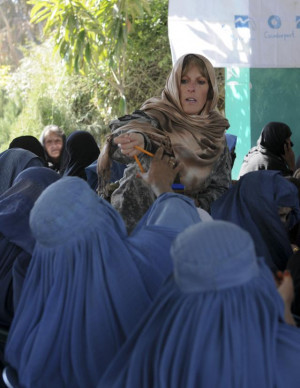 , Ind., hands out pencils to Afghan women at the International Women ...