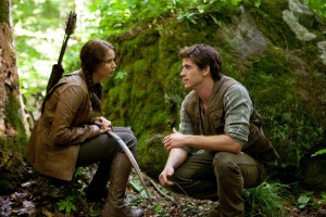 Katniss and Gale hunting in the woods.