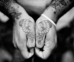 Mariposa tatuada en las manos