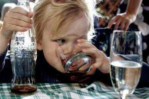 File photo of a young child drinking coca-cola from a glass, coke ...