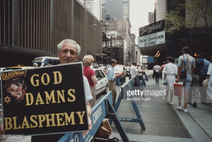with a 'God Damns Blasphemy' sign pickets the Ziegfeld Theater ...