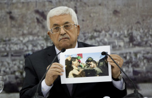 Palestinian President Mahmoud Abbas holds a picture of an Israeli