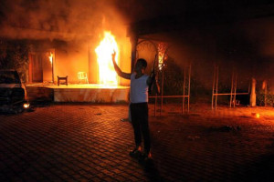 An armed man stands near the burning U.S. special mission in Benghazi ...