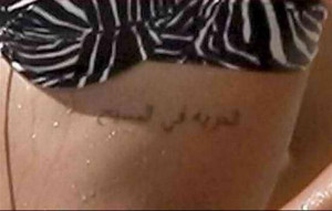 An Arabic script tattoo placed on her ribcage part which means ...