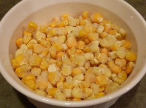 About 1 1/2 cups of frozen corn waiting to be added to the frying pan.