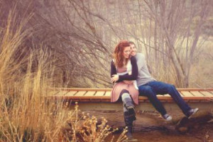 Young couple laugh together sitting on bridge - Anna Gorin/ Moment ...