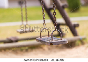 Empty swing on children playground in city. - stock photo