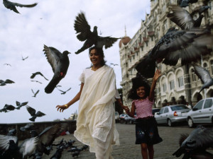 Photo: Pigeons flutter around a woman and her daughter