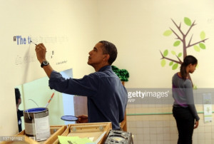 News Photo : President Barack Obama paints a quote of Martin...